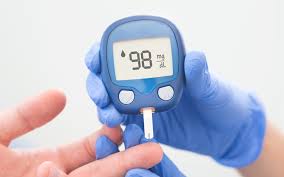 "Person having their blood sugar checked with a finger-prick test, using a glucose meter."