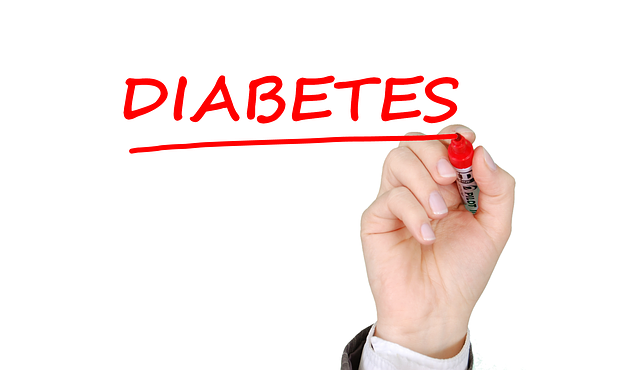 Hand writing the word 'Diabetes' in red marker, highlighting the focus on diabetes awareness.