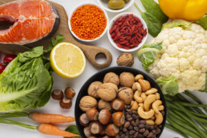 Healthy thyroid diet with fresh fruits, vegetables, and nuts on a white background.